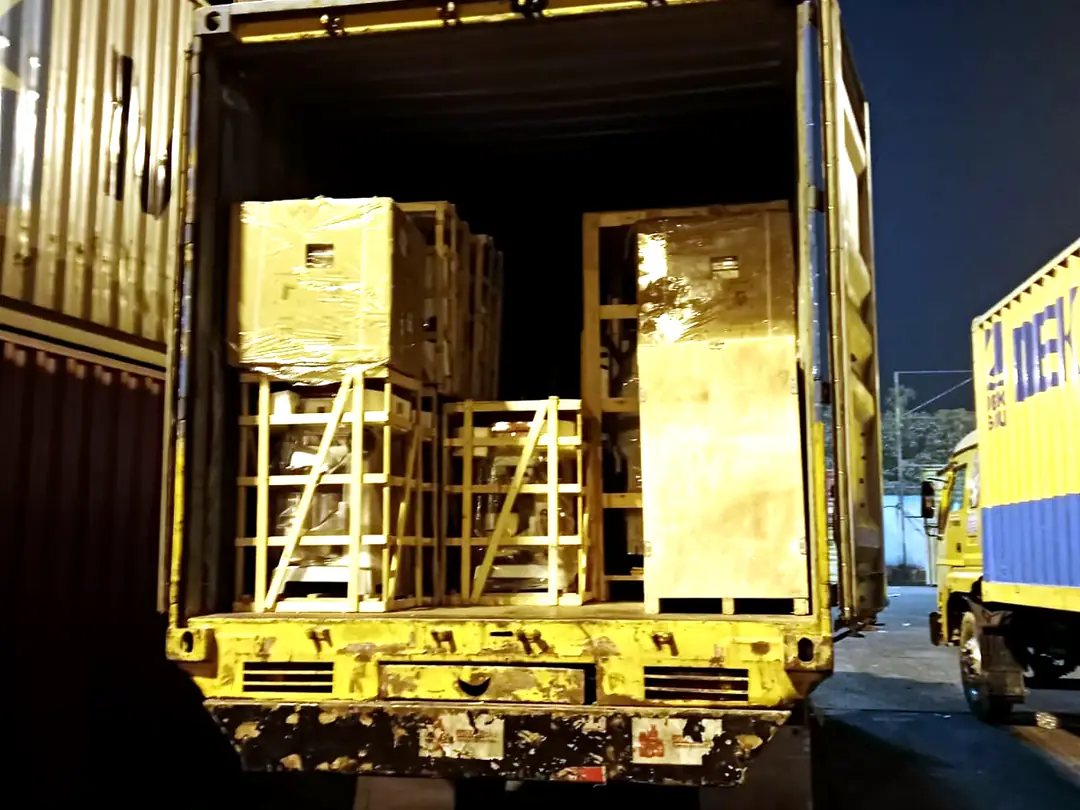 Machinery loaded into a container at night