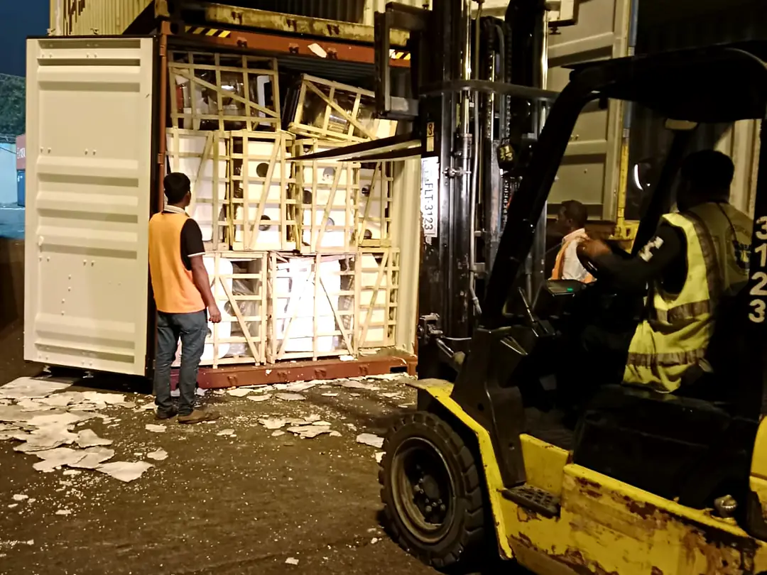 Forklift loading a container at night